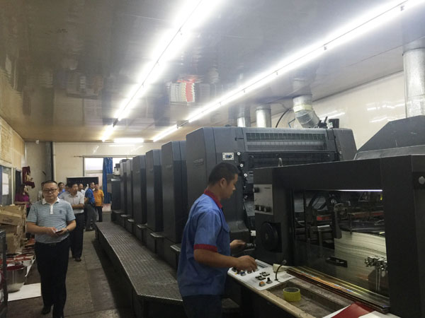 大家正在本色公司印刷车间参观其六色海德堡UV印刷机的生产